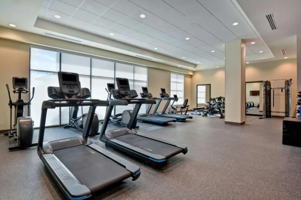 Sala de fitness con cintas de correr, una elíptica y una máquina de pesas en Home2 Suites Flamingo Crossings