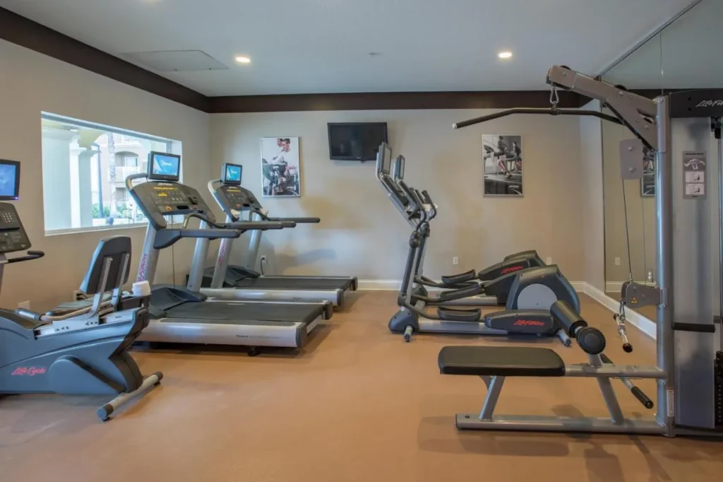 Sala de fitness con cintas de correr, m&aacute;quinas el&iacute;pticas y estaci&oacute;n de pesas en The Point Hotel & Suites