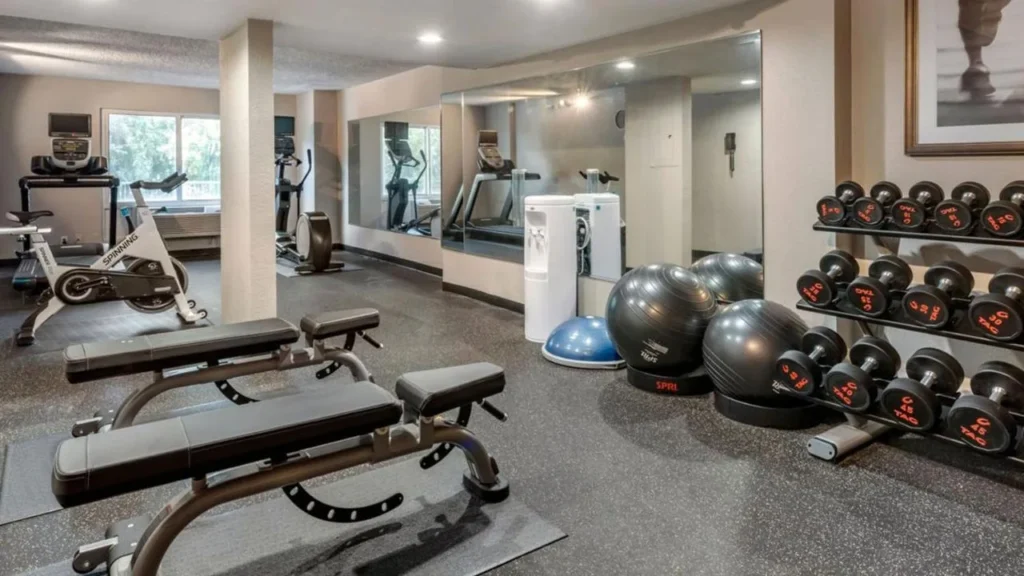 Fitness room with treadmills, spin bike, benches and dumbbells at Staybridge Suites Orlando Royale Parc