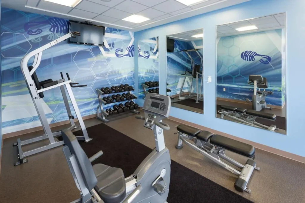 Fitness room with weight machine, dumbbells, bench and exercise bike at SpringHill Suites Orlando at SeaWorld