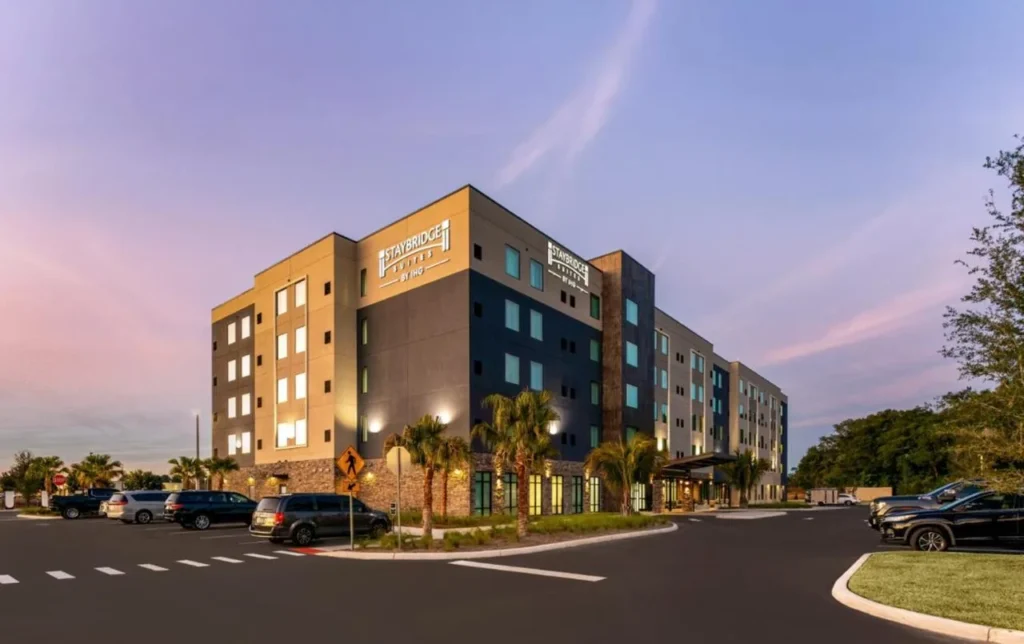 Exterior de cinco pisos y estacionamiento al anochecer en Staybridge Suites Ocala-cerca de Equestrian-Aquatics en US 27
