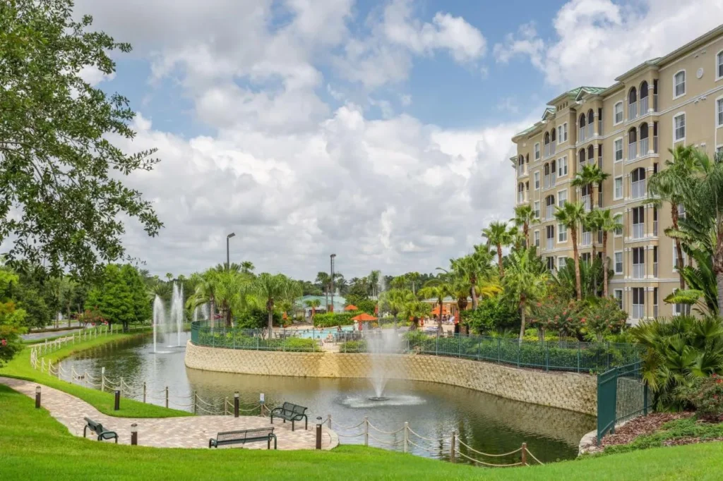Lago de la fuente, cubierta de la piscina y edificio de la suite en el Hilton Vacation Club Mystic Dunes Orlando