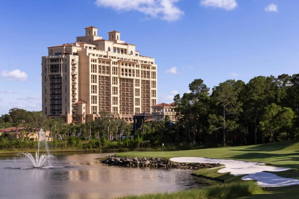 Four Seasons Resort Orlando tower rising behind a golf course pond with a fountain