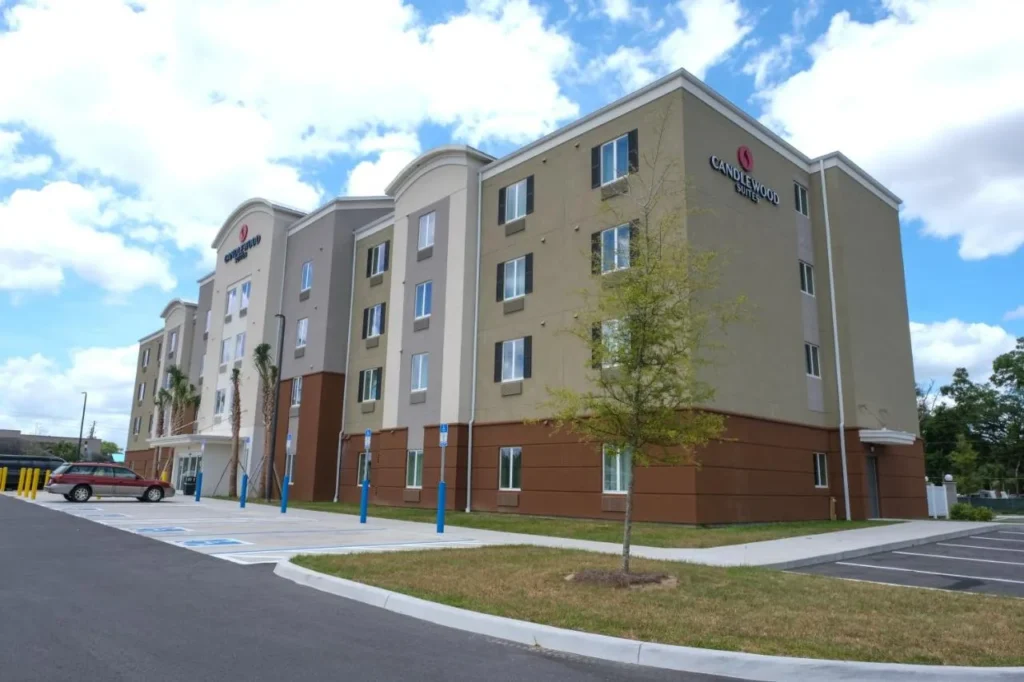 Exterior de cuatro pisos y &aacute;rea de estacionamiento bajo el cielo azul en Candlewood Suites Ocala I-75