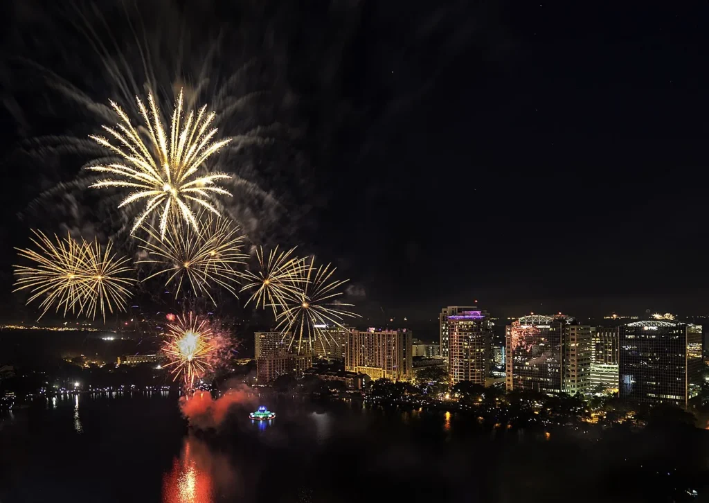 Fourth of July fireworks over Lake Eola and its lit fountain with downtown Orlando towers
