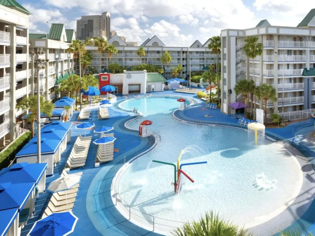 Piscina de forma libre con fuentes y caba&ntilde;as azules en Holiday Inn Resort Orlando Suites
