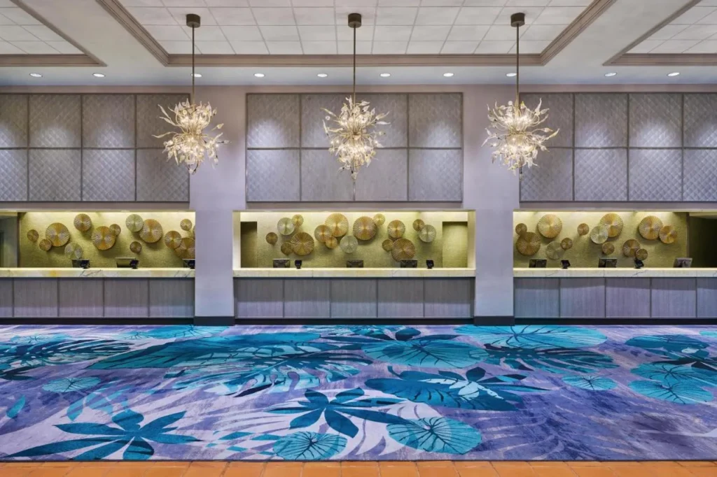 Front desk with chandeliers and a leaf-patterned carpet at Walt Disney World Dolphin