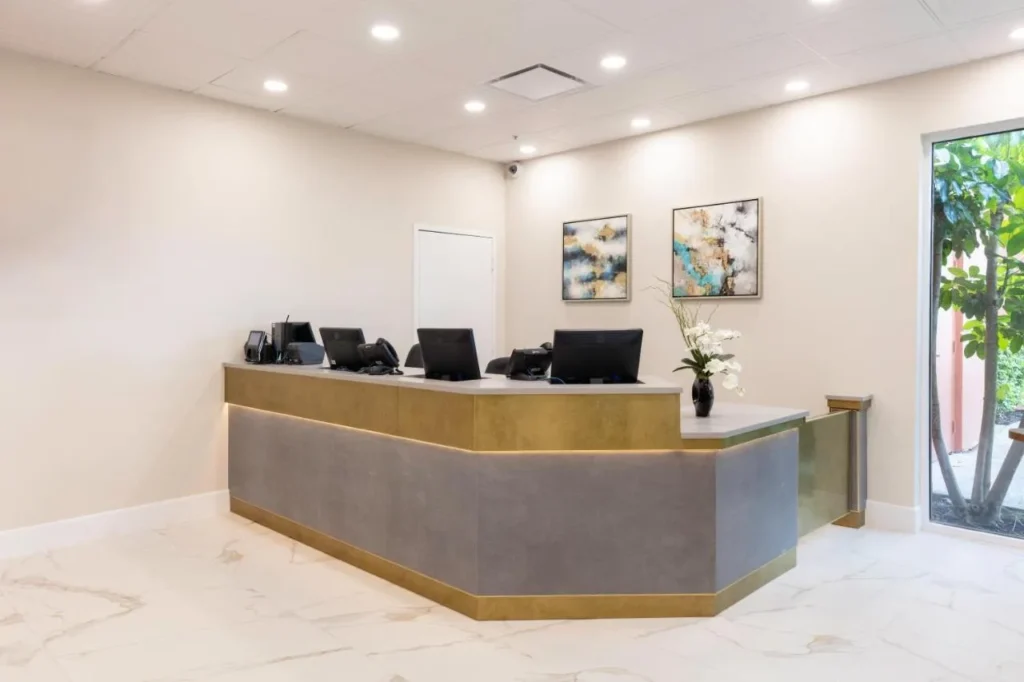Front desk with gold trim, abstract artwork and a garden window at Westgate Palace in Orlando
