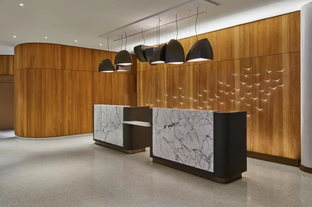 Front desk with marble counters, wood walls and bird sculptures at Walt Disney World Swan Reserve