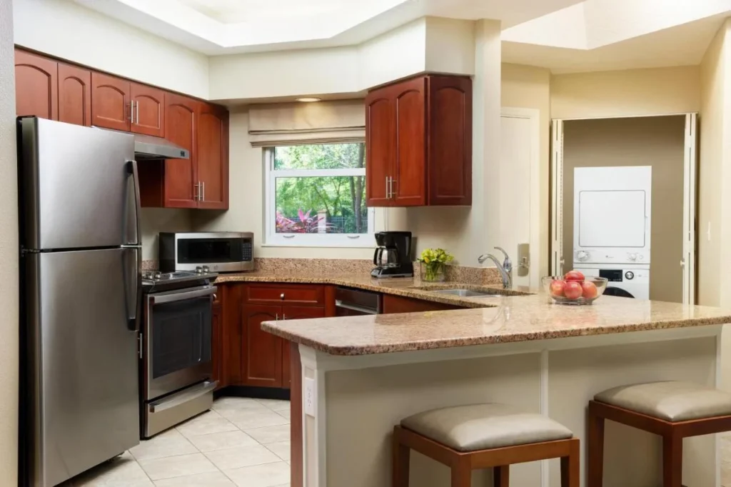 Cocina completa de la villa con refrigerador de acero inoxidable, horno y lavadora-secadora apilada en Sheraton Vistana Resort