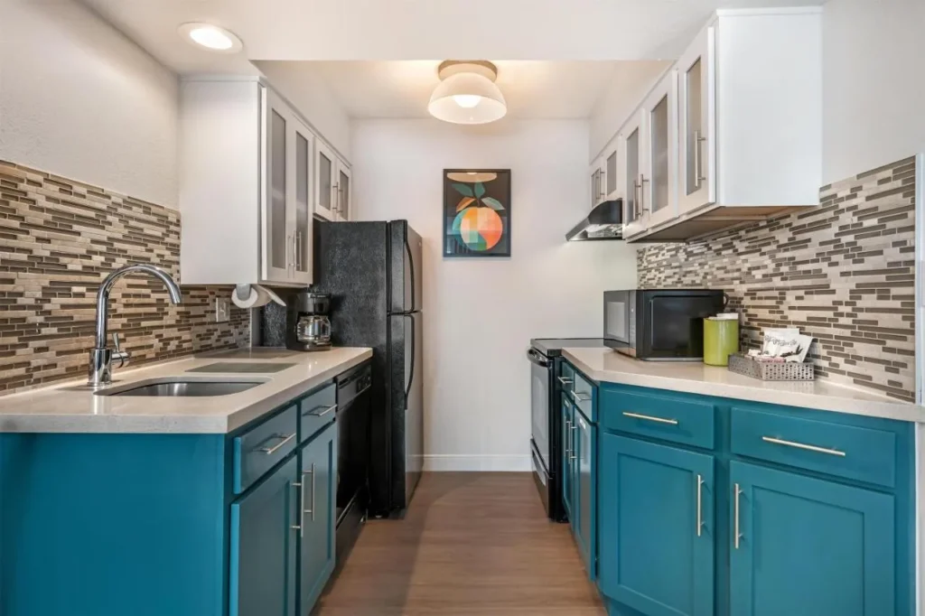 Cocina de galera con armarios de color verde azulado, refrigerador, estufa y microondas en Sonesta ES Suites Lake Buena Vista