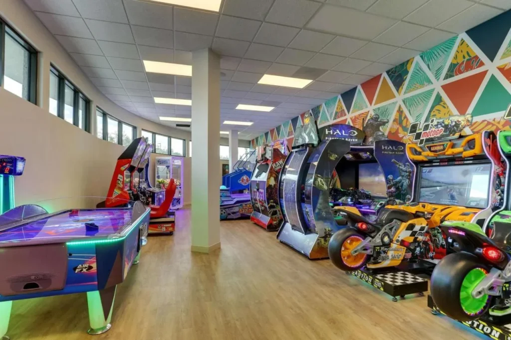 Sala de juegos con máquinas recreativas y una mesa de air hockey en Drury Plaza Hotel Orlando
