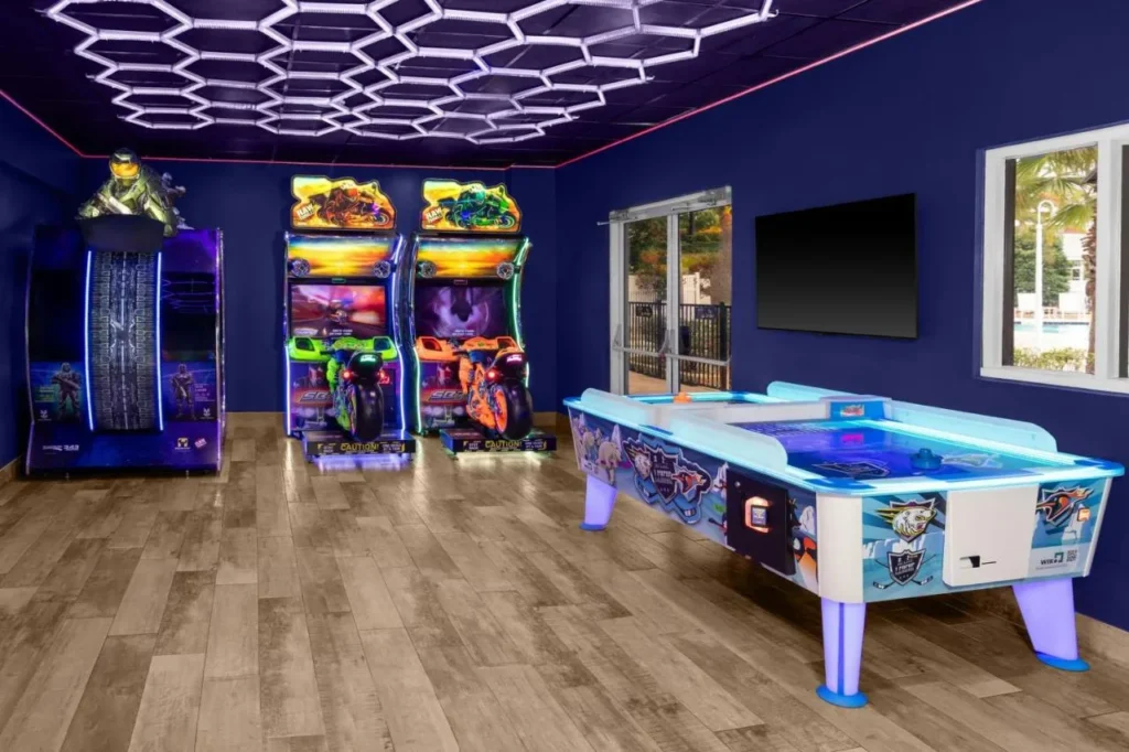 Sala de juegos con máquinas de carreras arcade y mesa de hockey de aire en Four Points Orlando International Drive