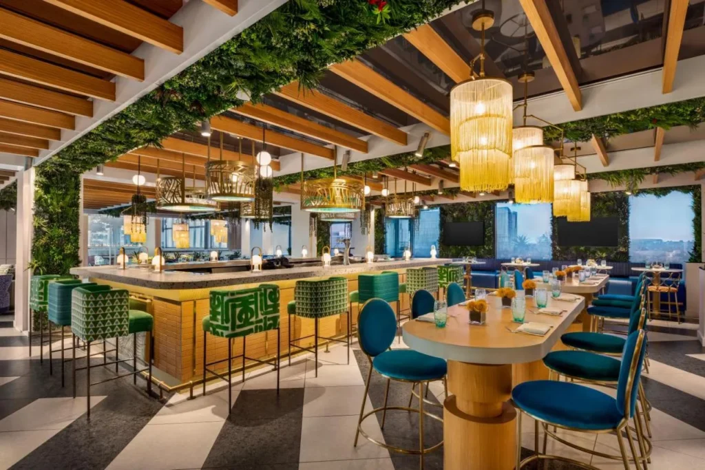 Garni Caf&eacute; con techo cubierto de plantas, colgantes con flecos y taburetes verdes, Lake Nona Wave Hotel