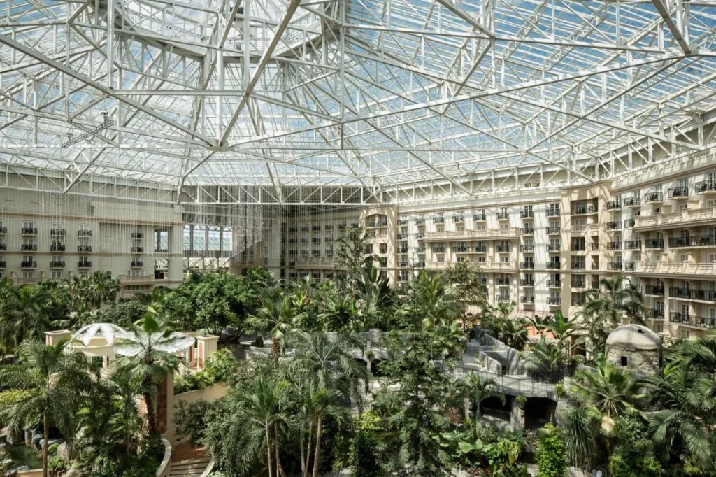 Glass-roofed atrium with tropical gardens and balconied guest wings at Gaylord Palms Resort