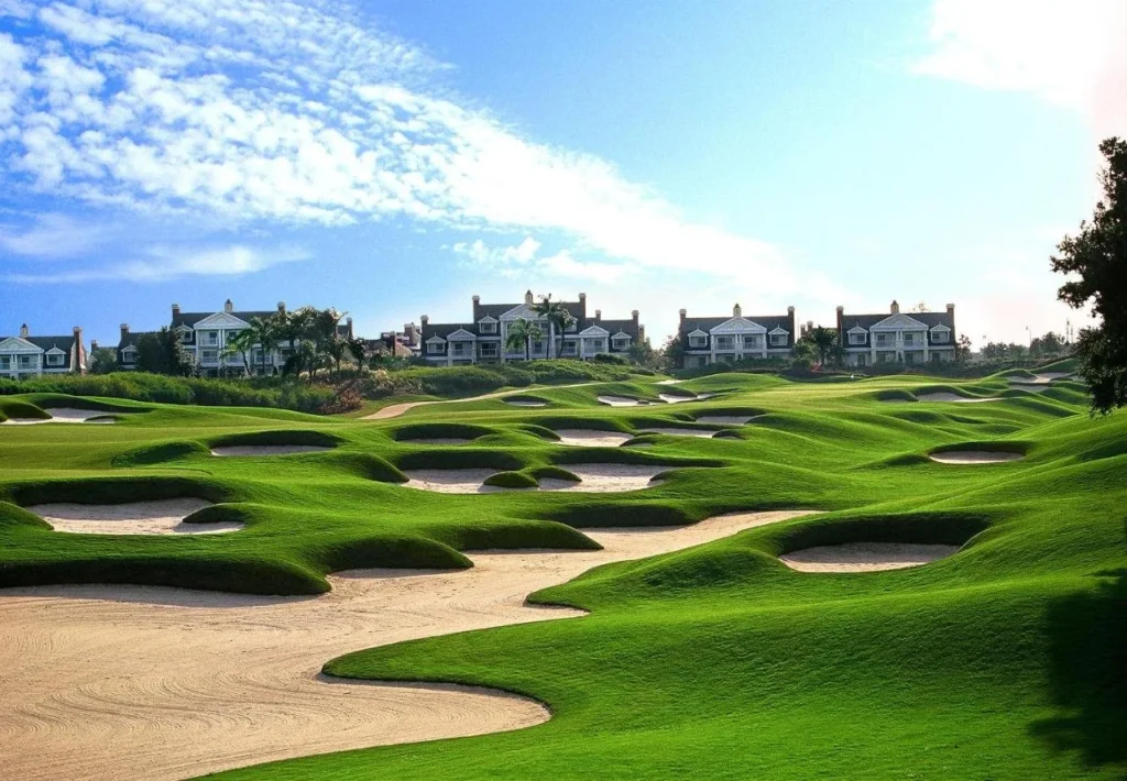 Campo de golf y bunkers de arena con grandes casas detr&aacute;s en Reunion Resort & Golf Club