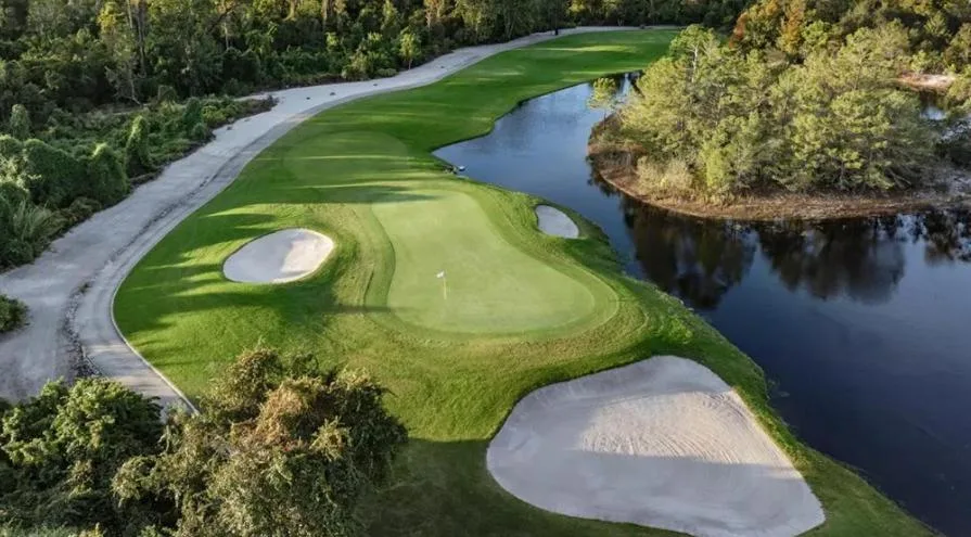 Golf green with sand bunkers beside a lake on an Orange Lake Resort course