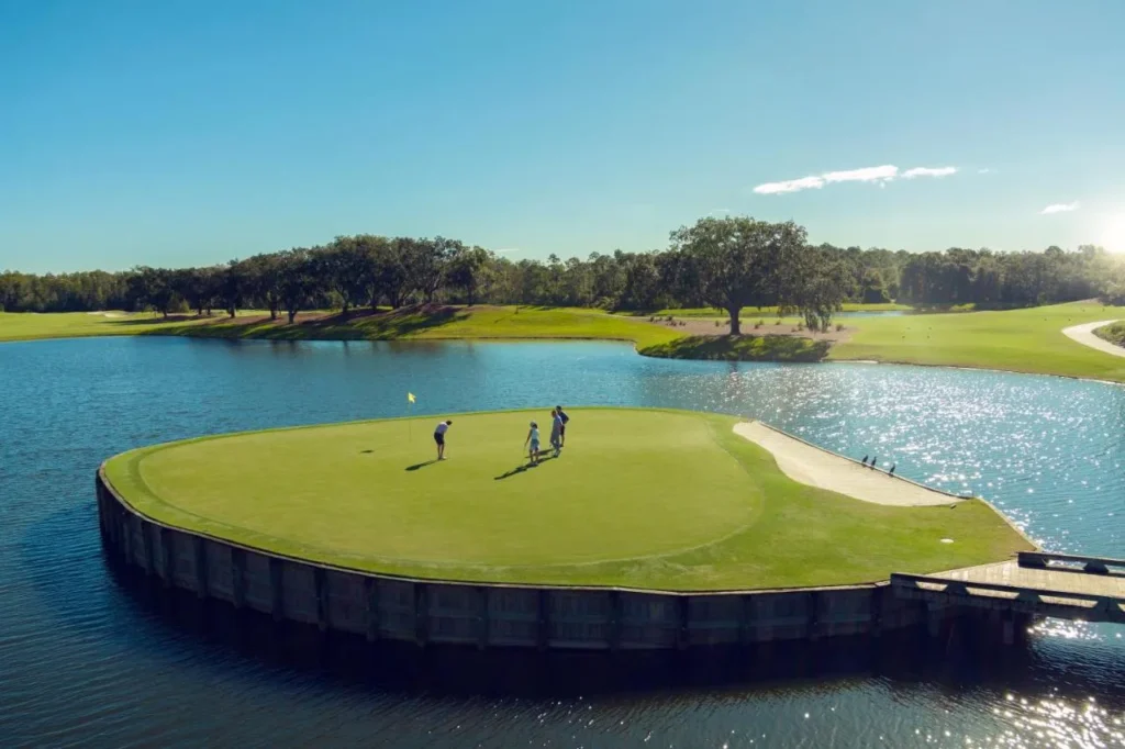 Golfers on an island green surrounded by water at Grand Cypress Golf, Evermore Orlando Resort