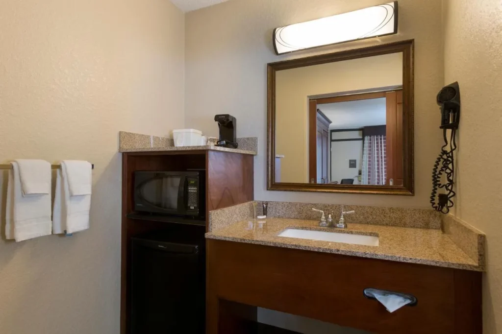 Tocador de granito junto a un microondas y un minirrefrigerador en una habitación en Rosen Inn at Pointe Orlando