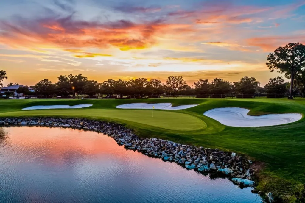 Green, bunkers and rock-lined pond at sunset at Arnold Palmer's Bay Hill Club & Lodge