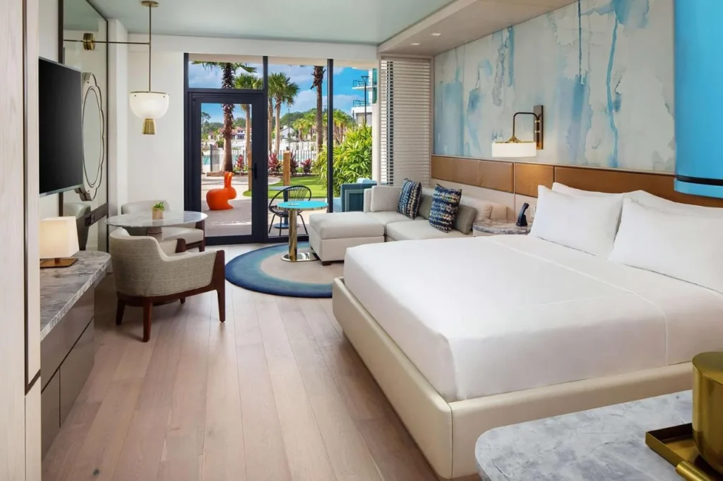 Habitaci&oacute;n con cama king en la planta baja que da a un patio y jard&iacute;n de palmeras en Conrad Orlando