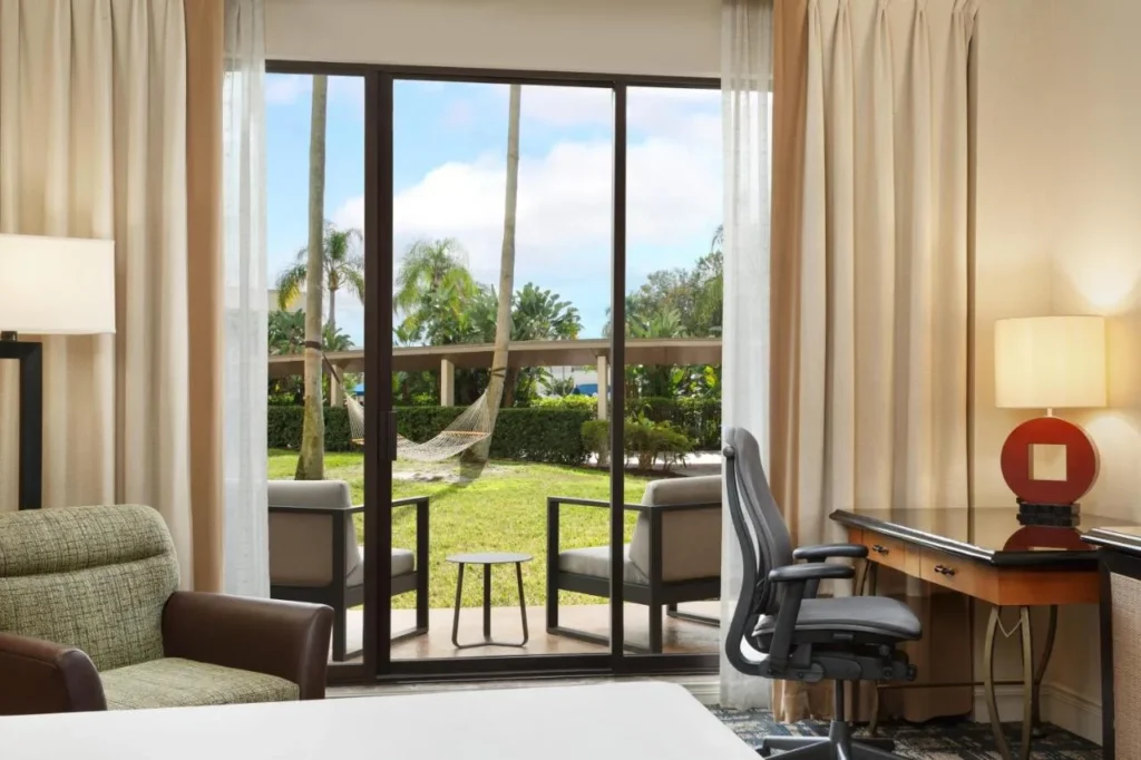 Habitación en planta baja con puertas correderas a un patio y césped en Hilton Orlando Lake Buena Vista