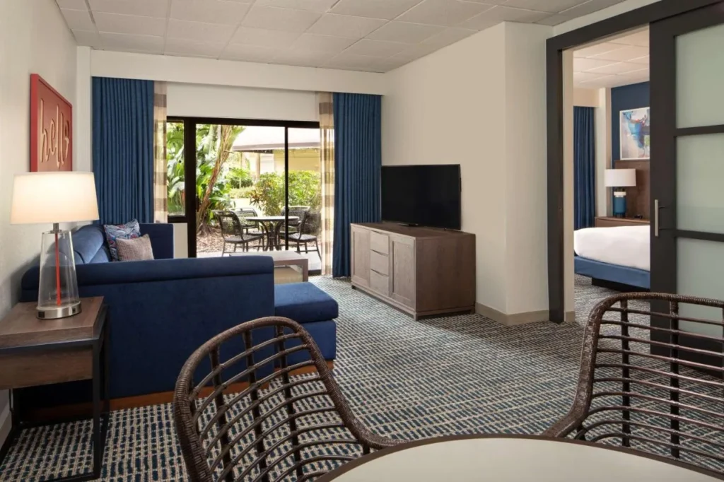Sala de estar de la suite de la planta baja con una puerta corredera a un patio en DoubleTree Suites Disney Springs