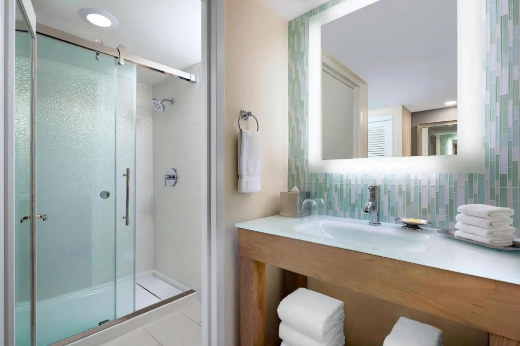 Guest bathroom with a glass shower and tiled vanity at Walt Disney World Dolphin