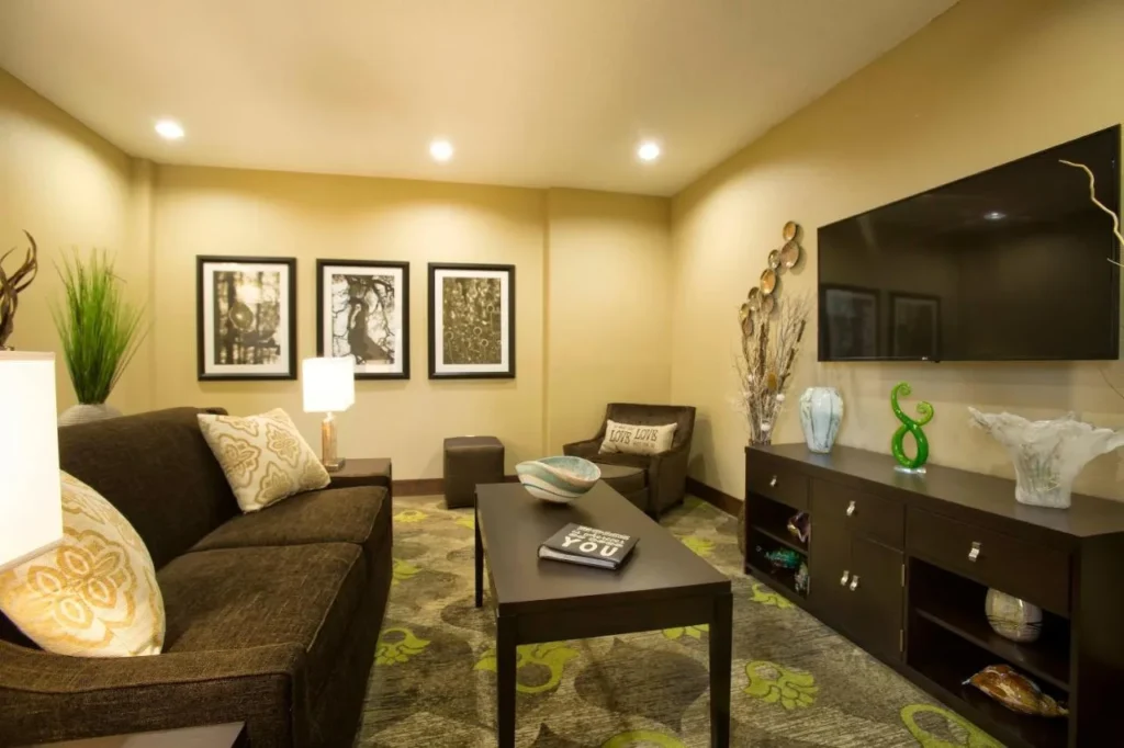 Salón de invitados con sofá, sillón y TV de pared en Staybridge Suites Orlando at SeaWorld