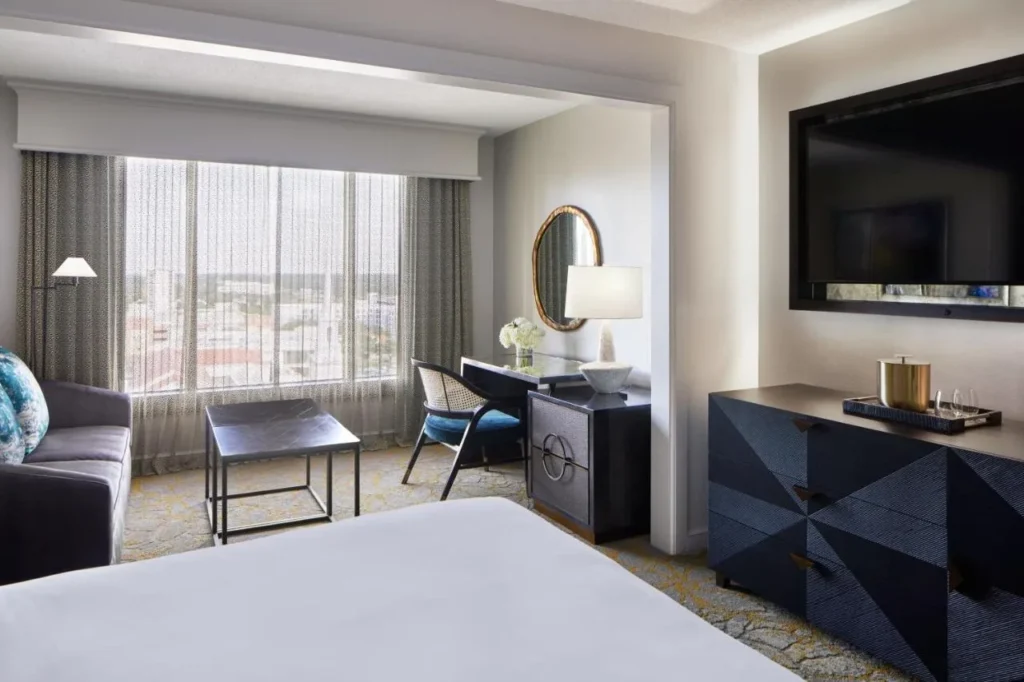 Guest room sitting area with desk and a large window over downtown Orlando, Hotel Beauden