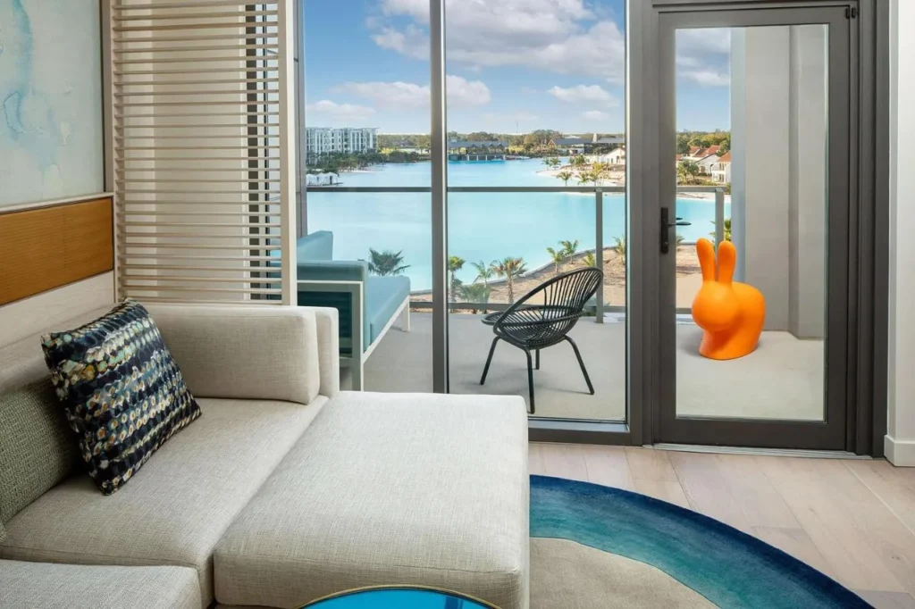 Habitaci&oacute;n con sof&aacute; y balc&oacute;n con vistas a Evermore Bay en Conrad Orlando