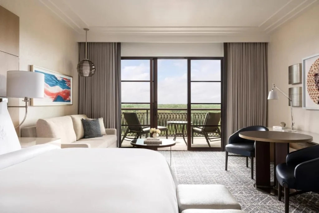 Habitaci&oacute;n con cama grande, sof&aacute; y balc&oacute;n amueblado en el Four Seasons Resort Orlando