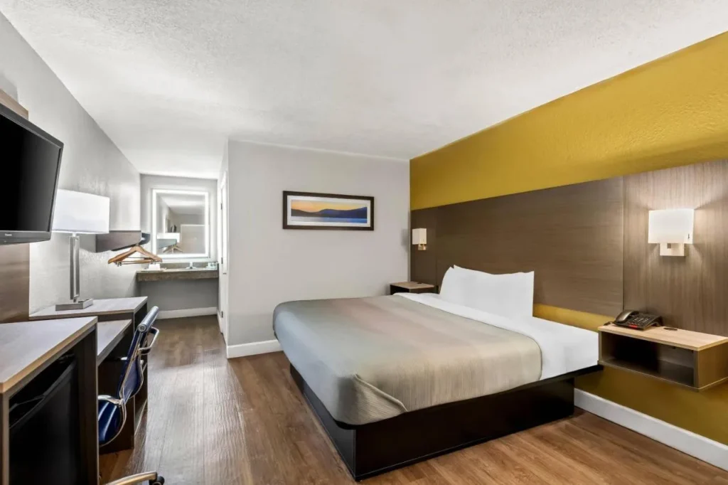 Guest room with one bed, wood-look floor and lighted vanity at Quality Inn Orange City