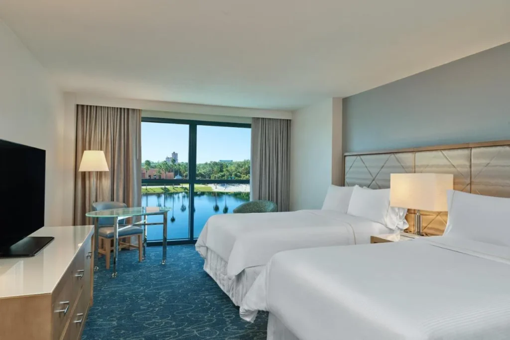 Habitación con dos camas y una ventana con vistas al lago de piso a techo en Walt Disney World Dolphin