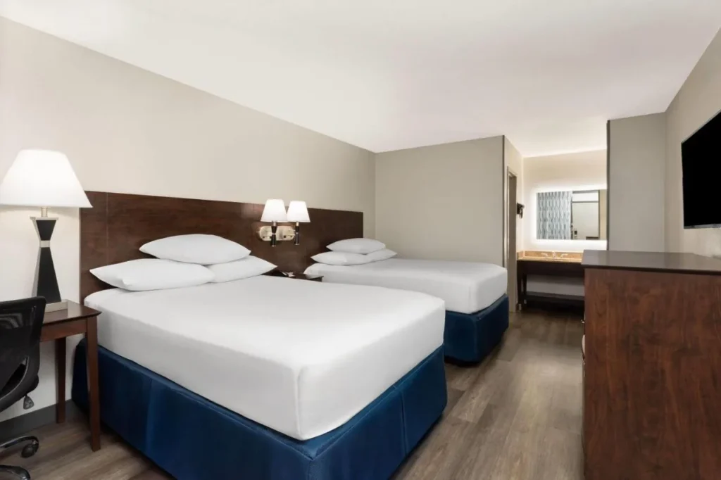 Habitación con dos camas y TV de pantalla plana en el Days Inn Orlando Convention Center