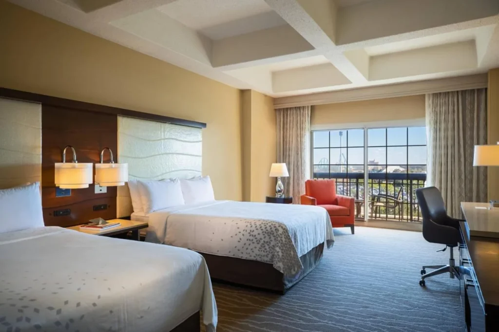 Guest room with two beds, armchair and balcony door at Renaissance Orlando at SeaWorld
