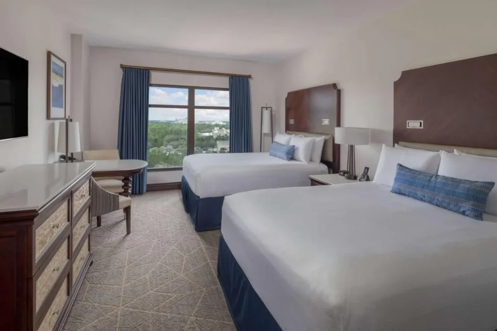Habitación con dos camas, cómoda y ventana en Wyndham Grand Orlando Resort Bonnet Creek