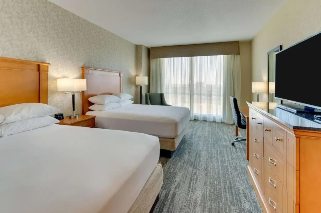 Habitación con dos camas, TV de pantalla plana y vestidor en Drury Inn & Suites Orlando