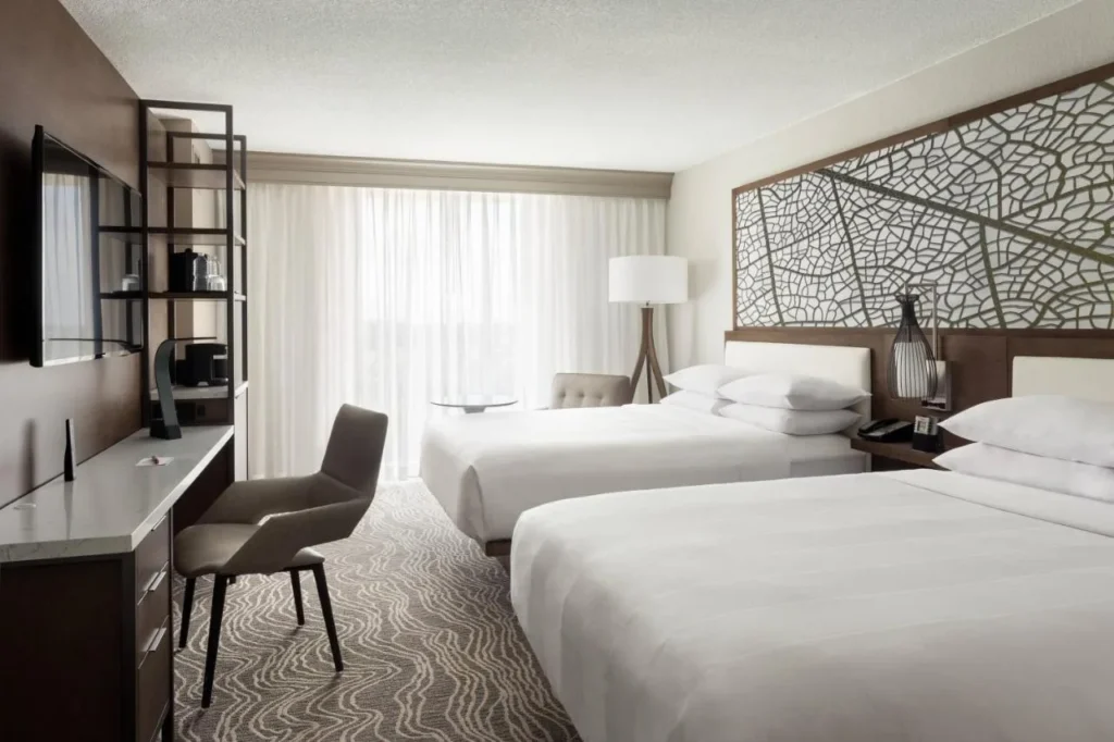 Guest room with two beds, leaf-pattern headboard wall and work desk at Marriott Orlando Airport Lakeside