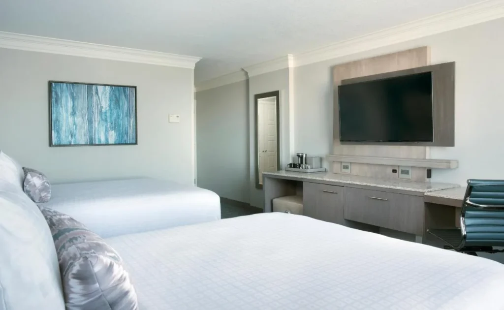 Habitación con dos camas, TV de pared y escritorio largo en Rosen Centre Hotel
