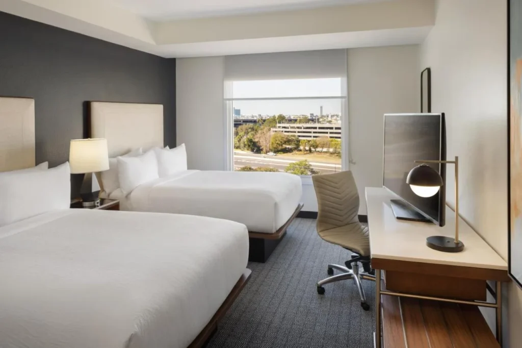 Habitaci&oacute;n con dos camas queen, un escritorio y una ventana en el Courtyard a trav&eacute;s de Universal Orlando