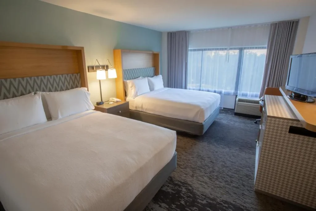 Habitaci&oacute;n con dos camas queen, una unidad de TV y una amplia ventana en Holiday Inn Orlando International Airport