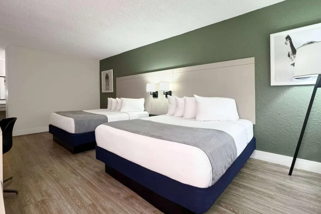 Habitación con dos camas queen y una pared de acento verde en Wyndham I-Drive Avanti Resort