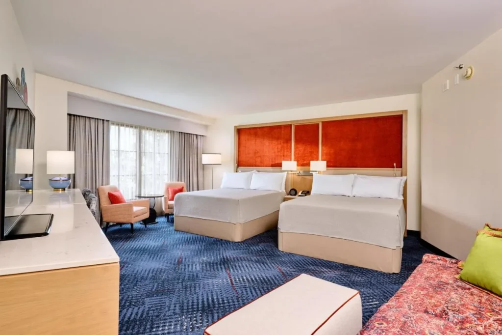 Habitación con dos camas queen, sillones y un sofá estampado en Hard Rock Hotel Orlando