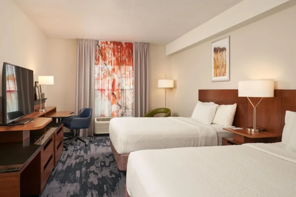 Habitación con dos camas queen, escritorio y TV en el Fairfield Inn & Suites International Drive