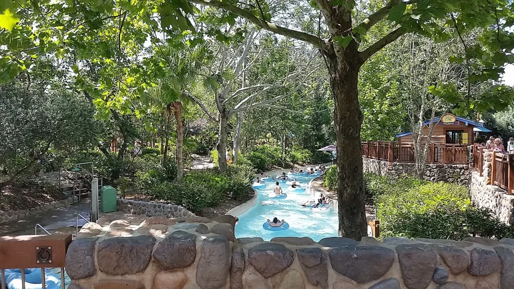 Invitados en tubos flotando a lo largo del sombreado río lento en el parque acuático Blizzard Beach de Disney