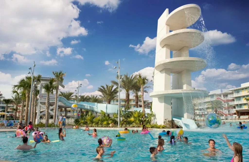 Los hu&eacute;spedes nadan en la piscina junto al tobog&aacute;n de la torre de buceo en Universal Cabana Bay Beach Resort