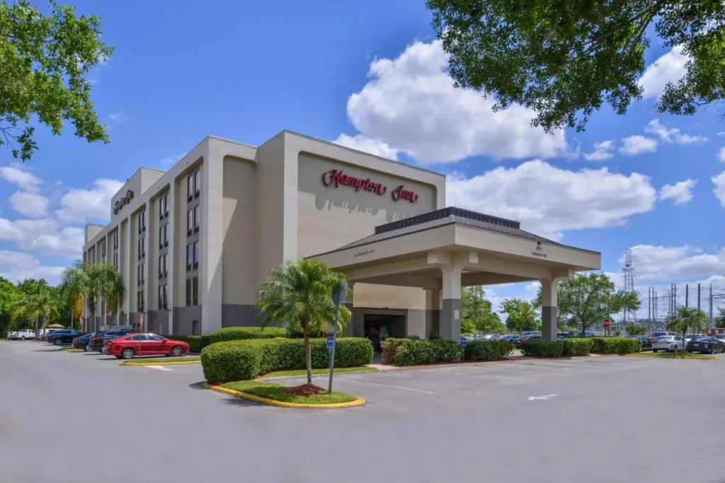 Hampton Inn Closest to Universal Orlando building, entrance canopy and surface parking lot
