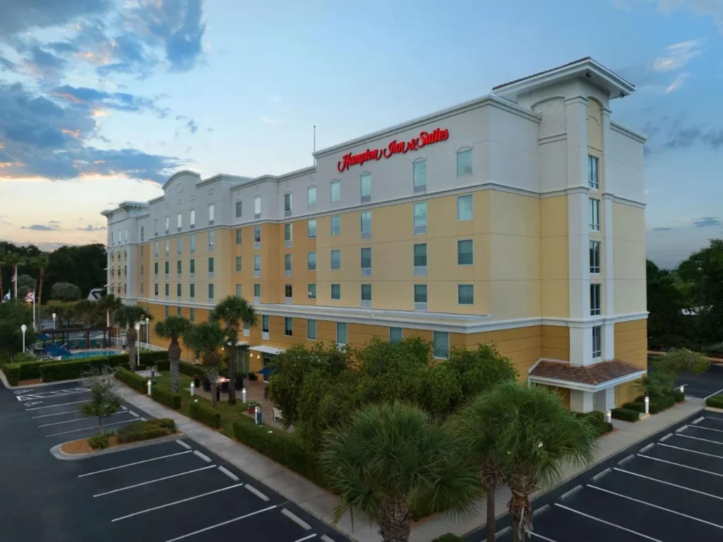 Hampton Inn & Suites Orlando-North/Altamonte Springs exterior al atardecer con palmeras y estacionamiento