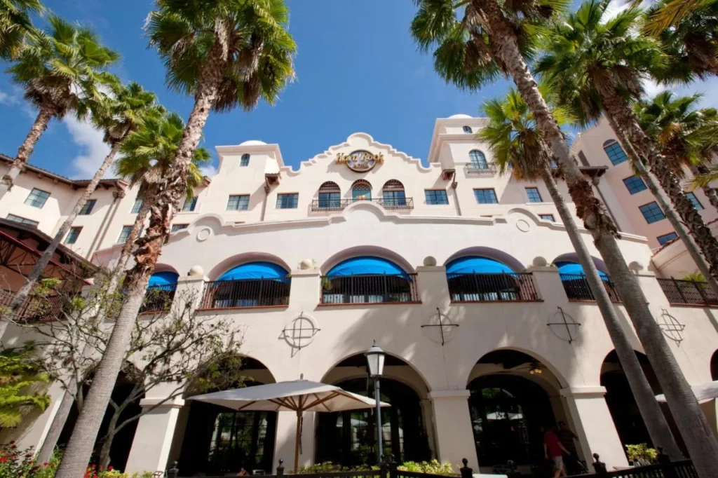Hard Rock Hotel en Universal Orlando fachada de estilo misión con arcos, toldos azules y palmas altas